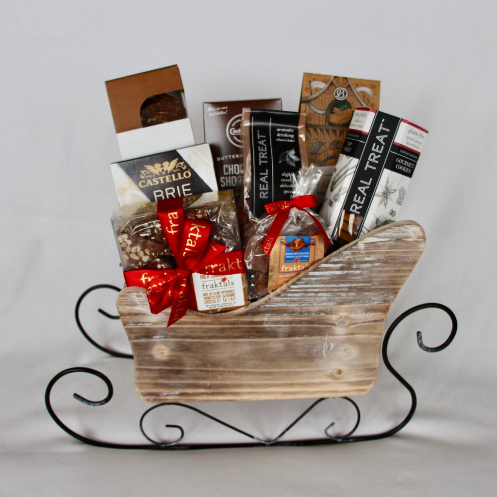 Adorable festive sleigh gift basket filled with the most delectable chocolates, shortbread, artisan crackers and more all made locally in Canada with the finest ingredients.